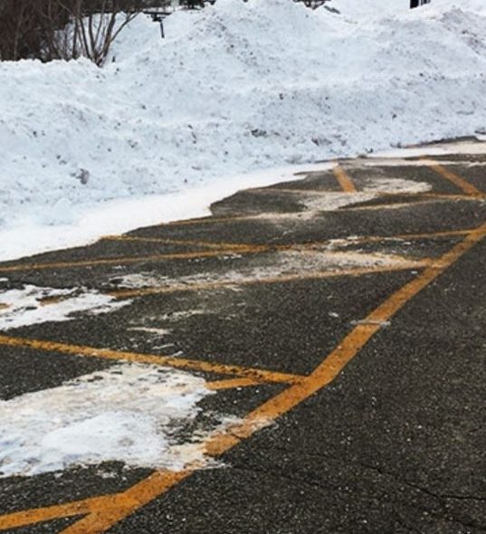 Parking lot with treated pavement and plowed snow edges