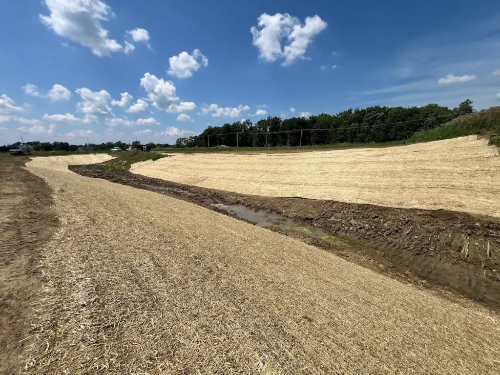 Seed and straw blanket along a new drainage swale