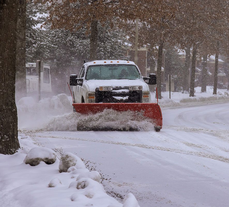 Earth and Turf truck plowing a snowy neighborhood street